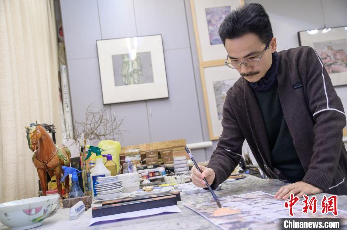 图为翁志承在为抗疫系列的画作进行润色。 李南轩 摄 图为翁志承在为抗疫系列的画作进行润色。 李南轩 摄