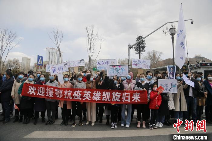 图为市民高举写有医疗队队员姓名的牌子夹道欢迎。 马铭言 摄 图为市民高举写有医疗队队员姓名的牌子夹道欢迎。 马铭言 摄