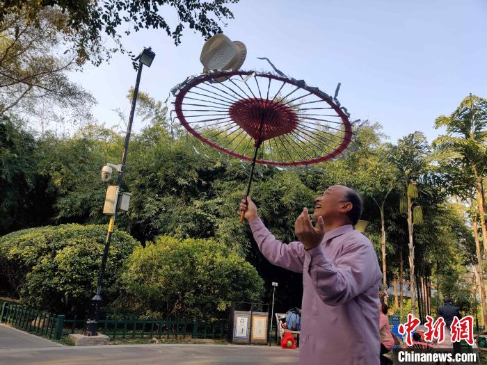 福州金瓯民间伞技队队员罗桂生正在福州市温泉公园排练。 叶秋云 摄 福州金瓯民间伞技队队员罗桂生正在福州市温泉公园排练。 叶秋云 摄