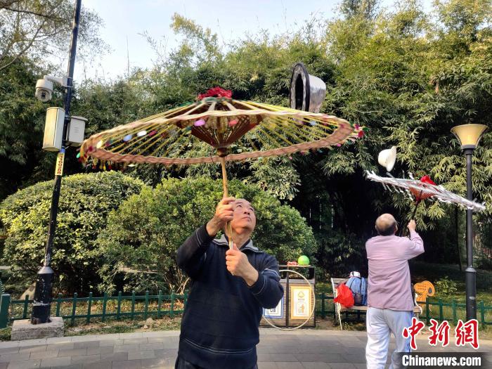 福州金瓯民间伞技队队员严振祥正在福州市温泉公园排练。 叶秋云 摄 福州金瓯民间伞技队队员严振祥正在福州市温泉公园排练。 叶秋云 摄