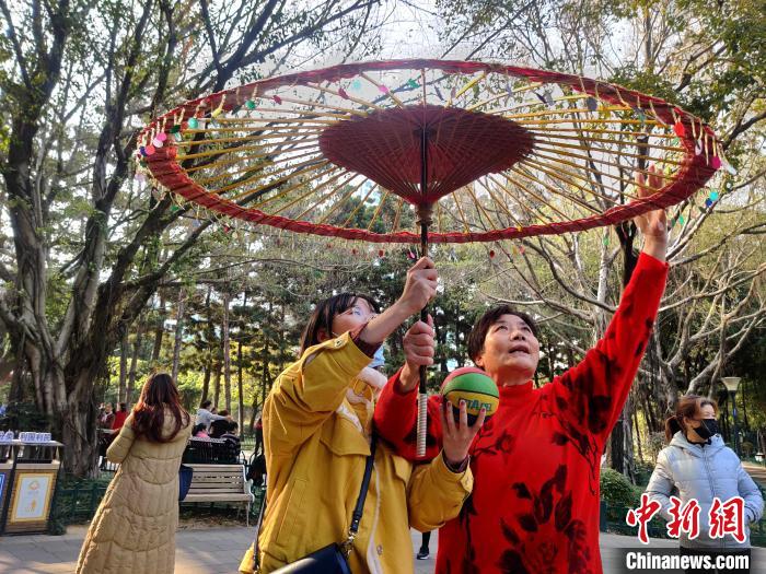 福州金瓯民间伞技队创始人王水英(右一)指导“90后”福州市民进行尝试。 叶秋云 摄 福州金瓯民间伞技队创始人王水英(右一)指导“90后”福州市民进行尝试。 叶秋云 摄